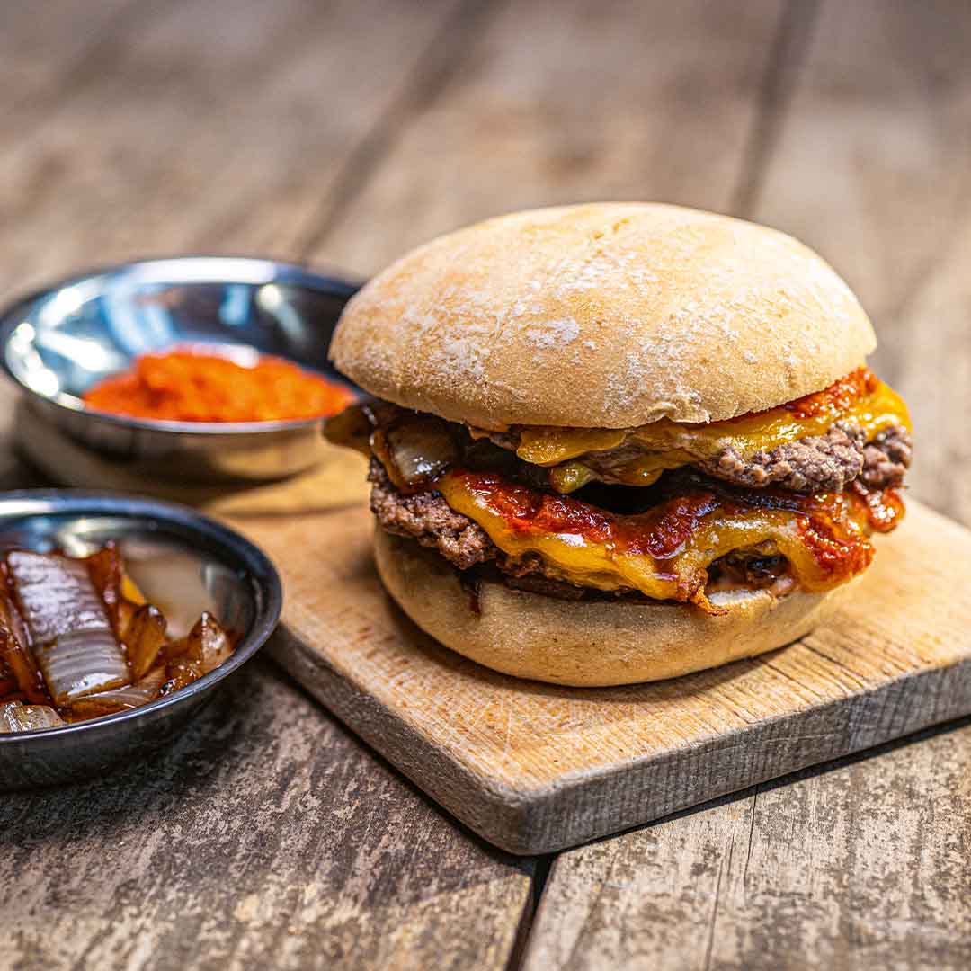 Rezeptbild "Smashed Cheeseburger" aus dem Buch "Grillen wie ein Bär XXL | 111 Rezepte für Grill und Dutch Oven" von Michael Schiller, auch bekannt als @thebbqbear